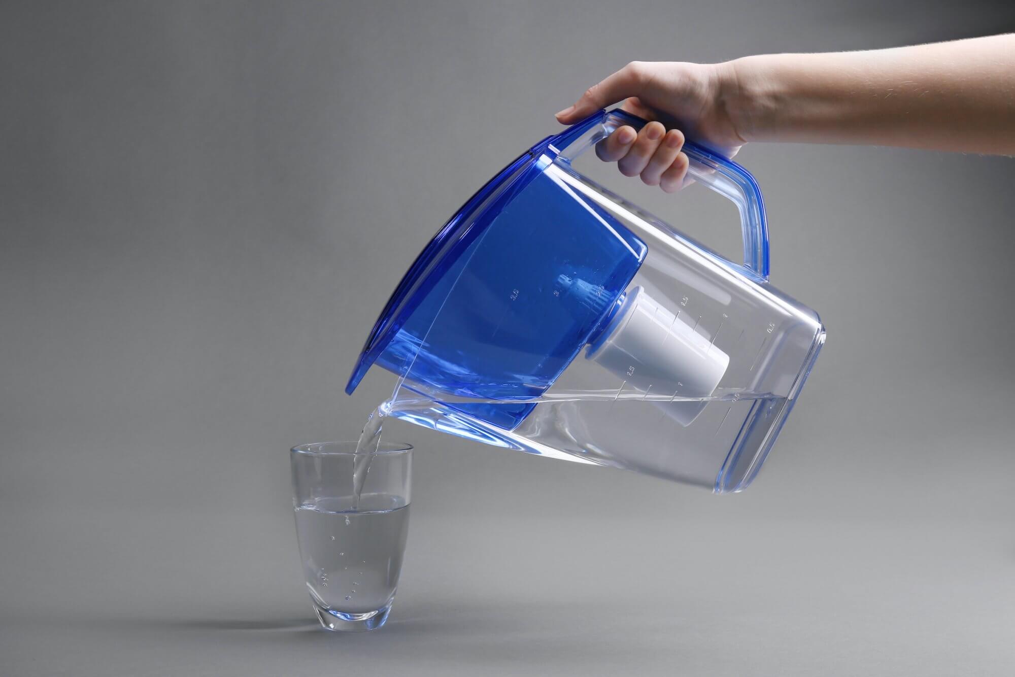 L'eau d'une carafe filtrante est versée dans un verre