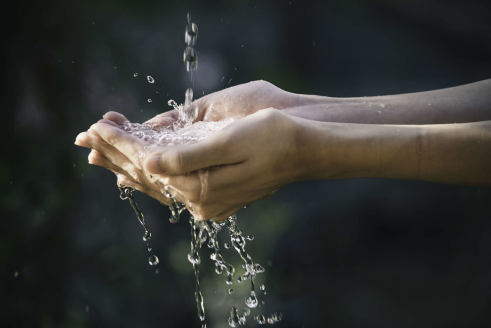 main récupérant une eau pure à la source